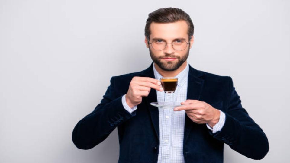 man holding a cup of coffee espresso